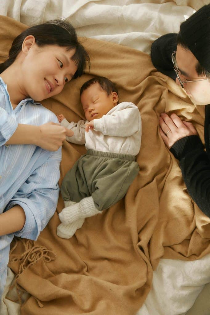 Mom, dad and baby laying down looking happy and snuggly at Story Wesley Chapel apartments for rent
